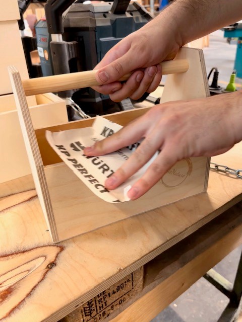 Putzkiste Lieschen beim Schleifen in den VARIUS Werkstätten Putzkiste Lieschen aus Holz wird in der Schreinerei der VARIUS Werkstätten von Hand geschliffen